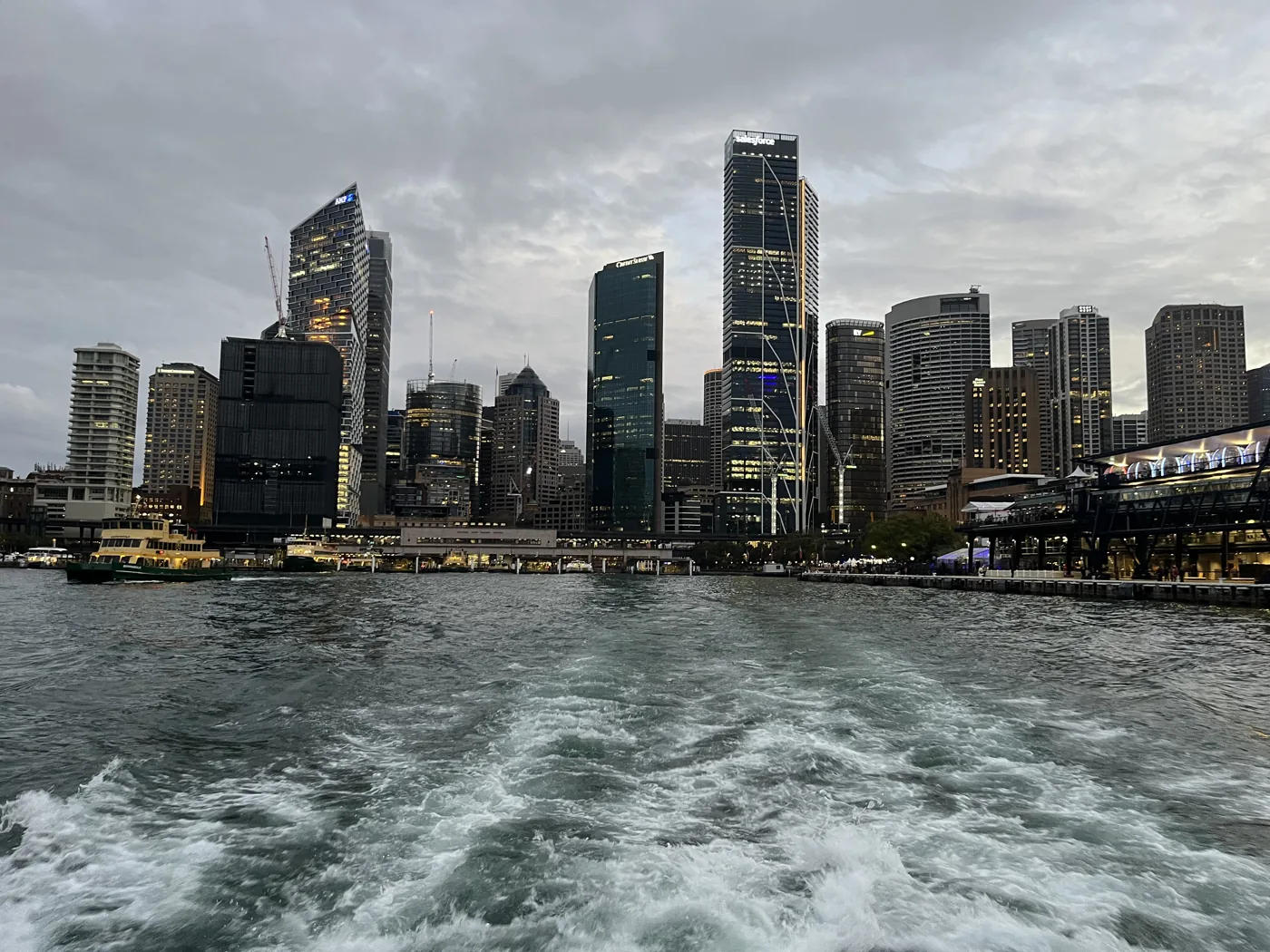 Sydney CBD skyline viewed from a departing ferry, wake trailing behind