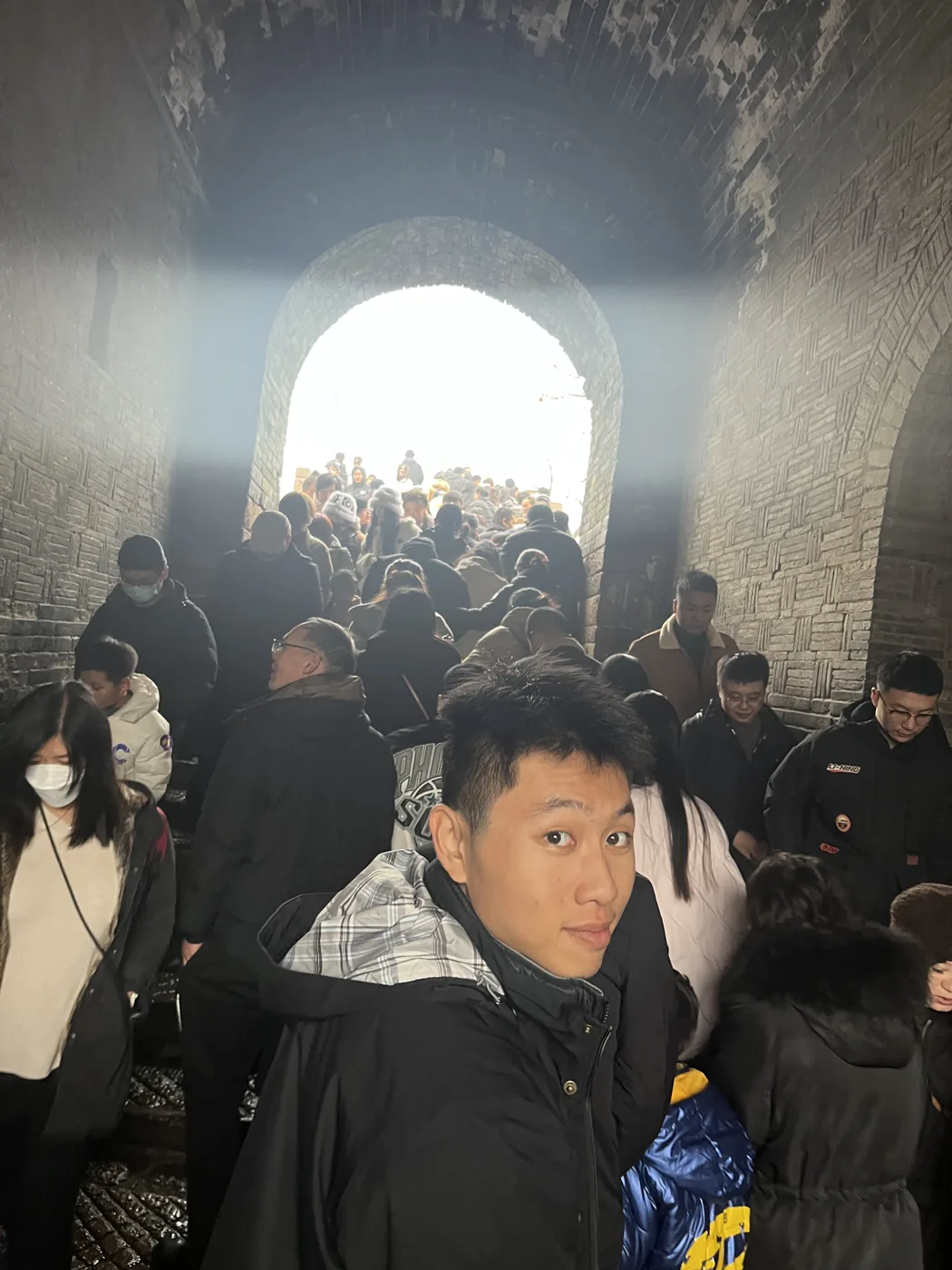 Selfie inside a packed Great Wall watchtower arch, crowd pushing through