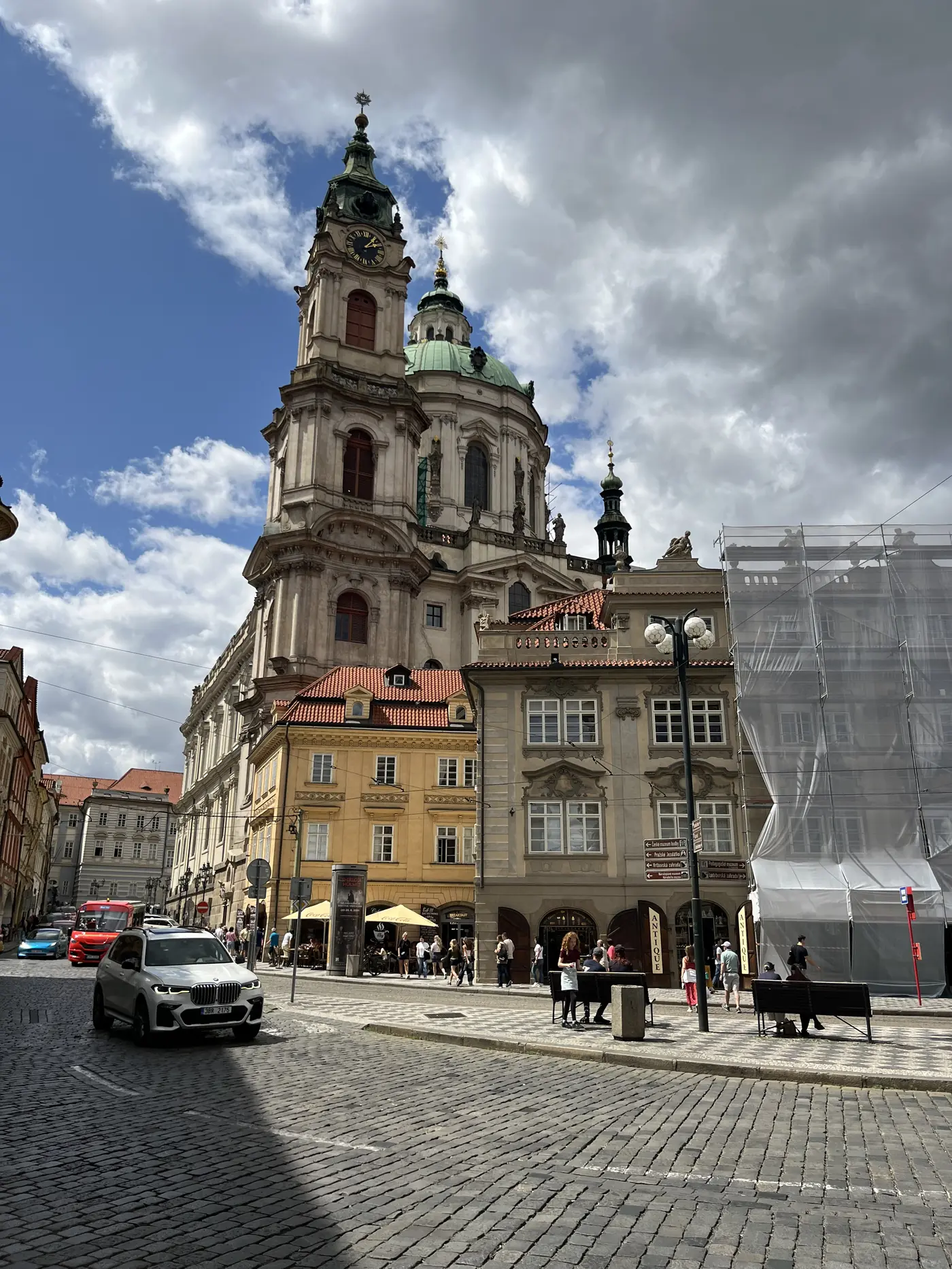 Baroque St. Nicholas Church in Malá Strana with its green dome and bell tower rising above a cobblestone square