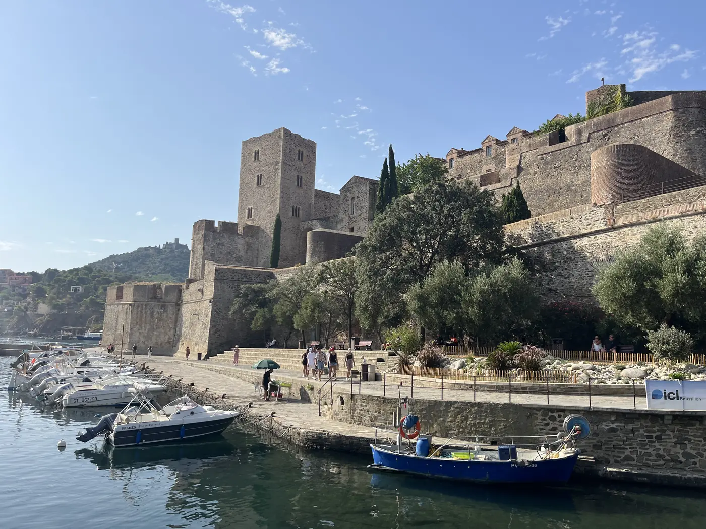 The Château Royal de Collioure, a fortified castle on the waterfront, with small fishing boats moored in the harbour below