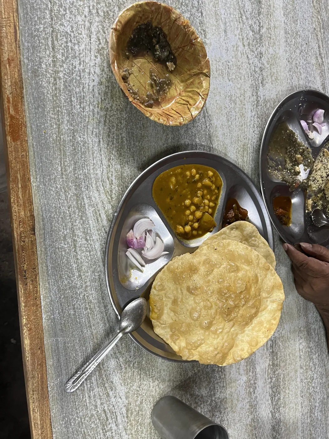 Puri and chole on a steel thali plate, Bihar