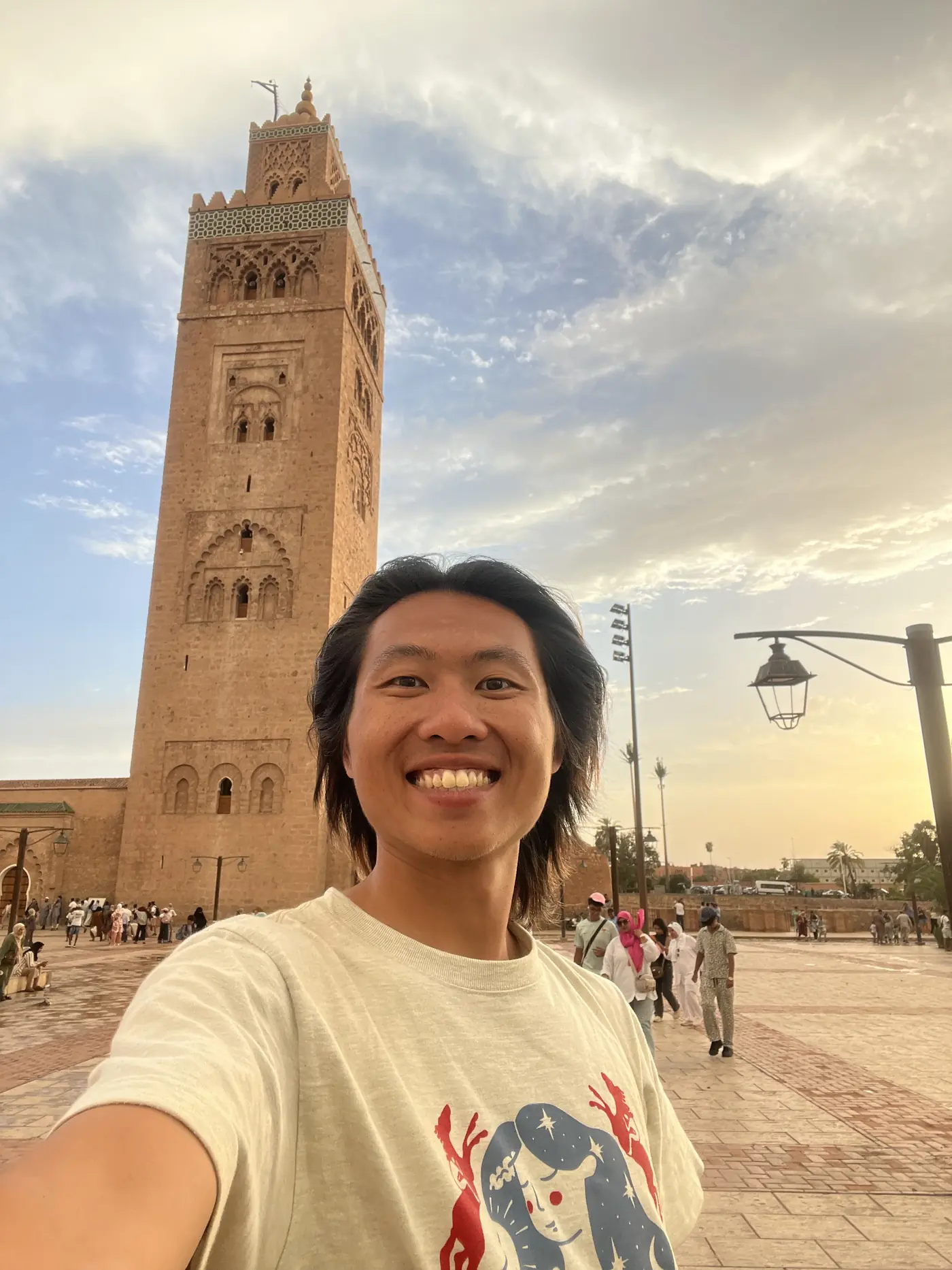 Shin selfie at golden hour in front of the Koutoubia Mosque's minaret in Marrakech