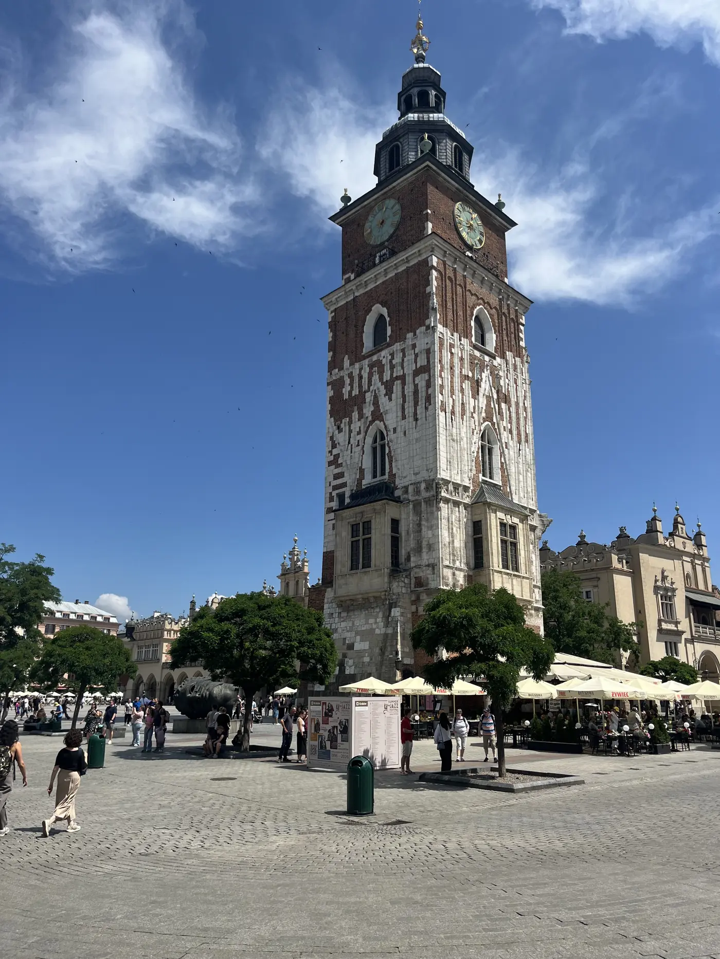 Kraków Town Hall Tower, a tall brick and stone tower with clock faces, standing alone in the Main Market Square
