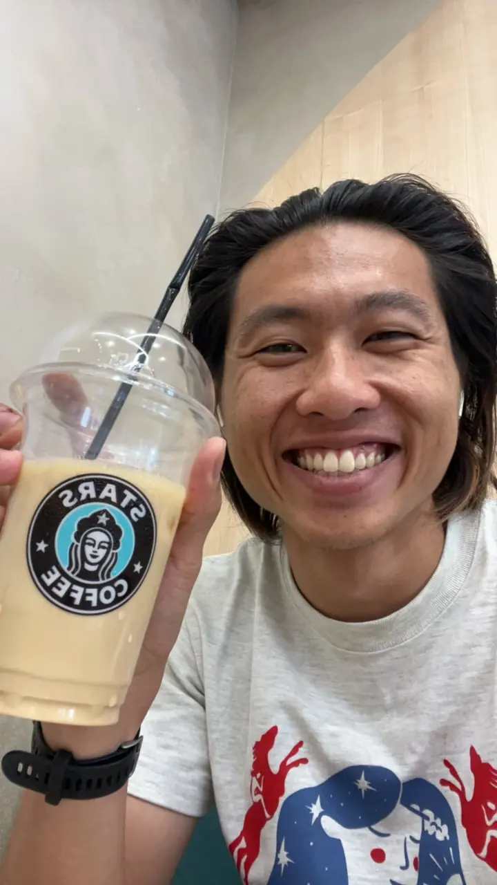 Shin grinning and holding an iced coffee from Stars Coffee, the Russian replacement for Starbucks, in Irkutsk