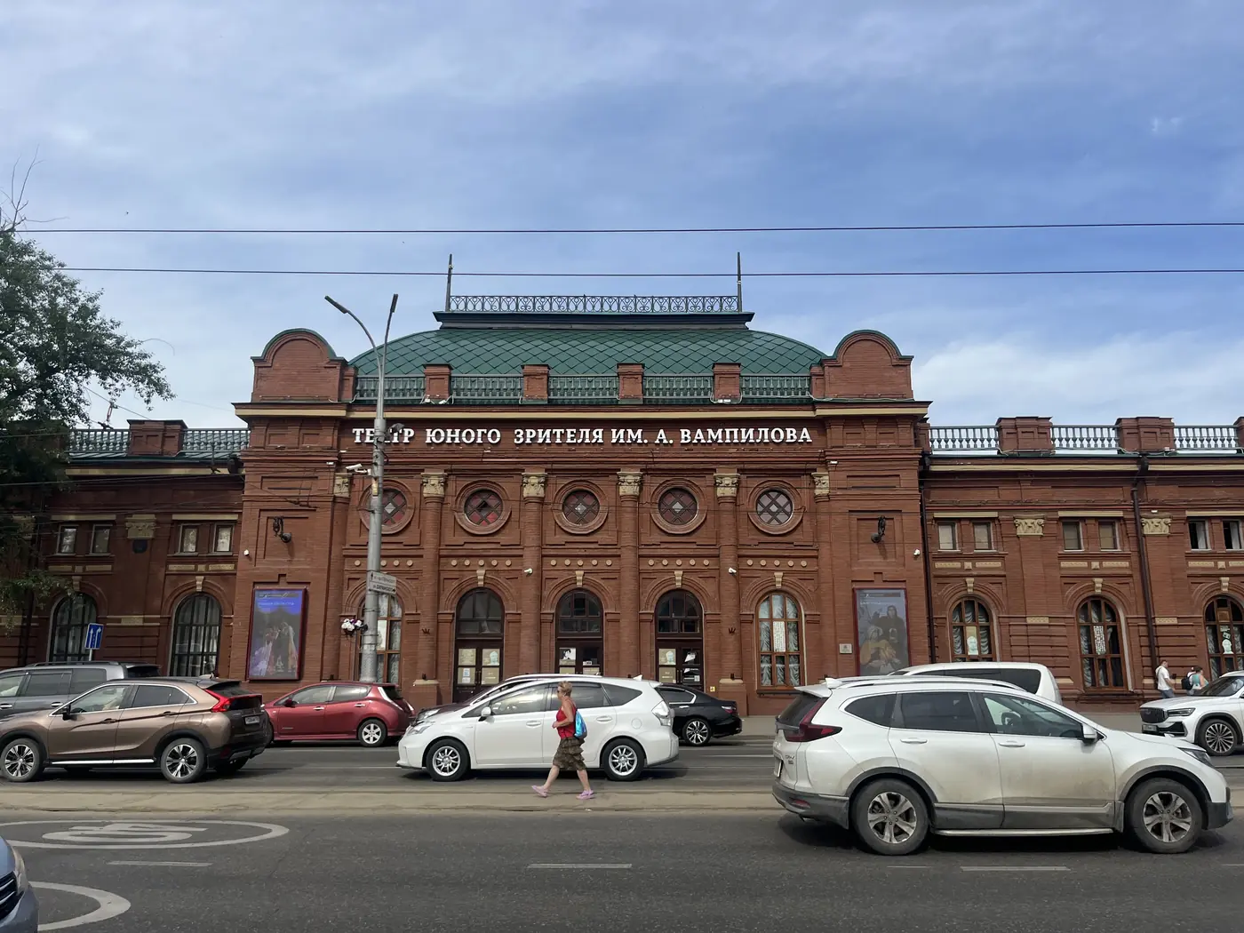 Vampilov Youth Theatre red brick building with green dome on Irkutsk city street, historic tsarist-era architecture in Siberia