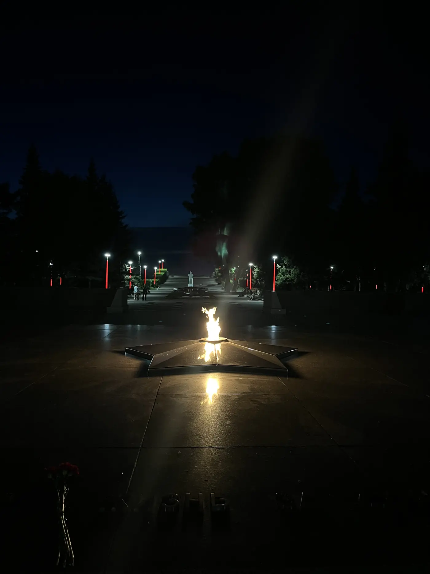 Eternal Flame memorial at night in Irkutsk, five-pointed star monument with flame burning in darkness, WWII memorial in Siberia