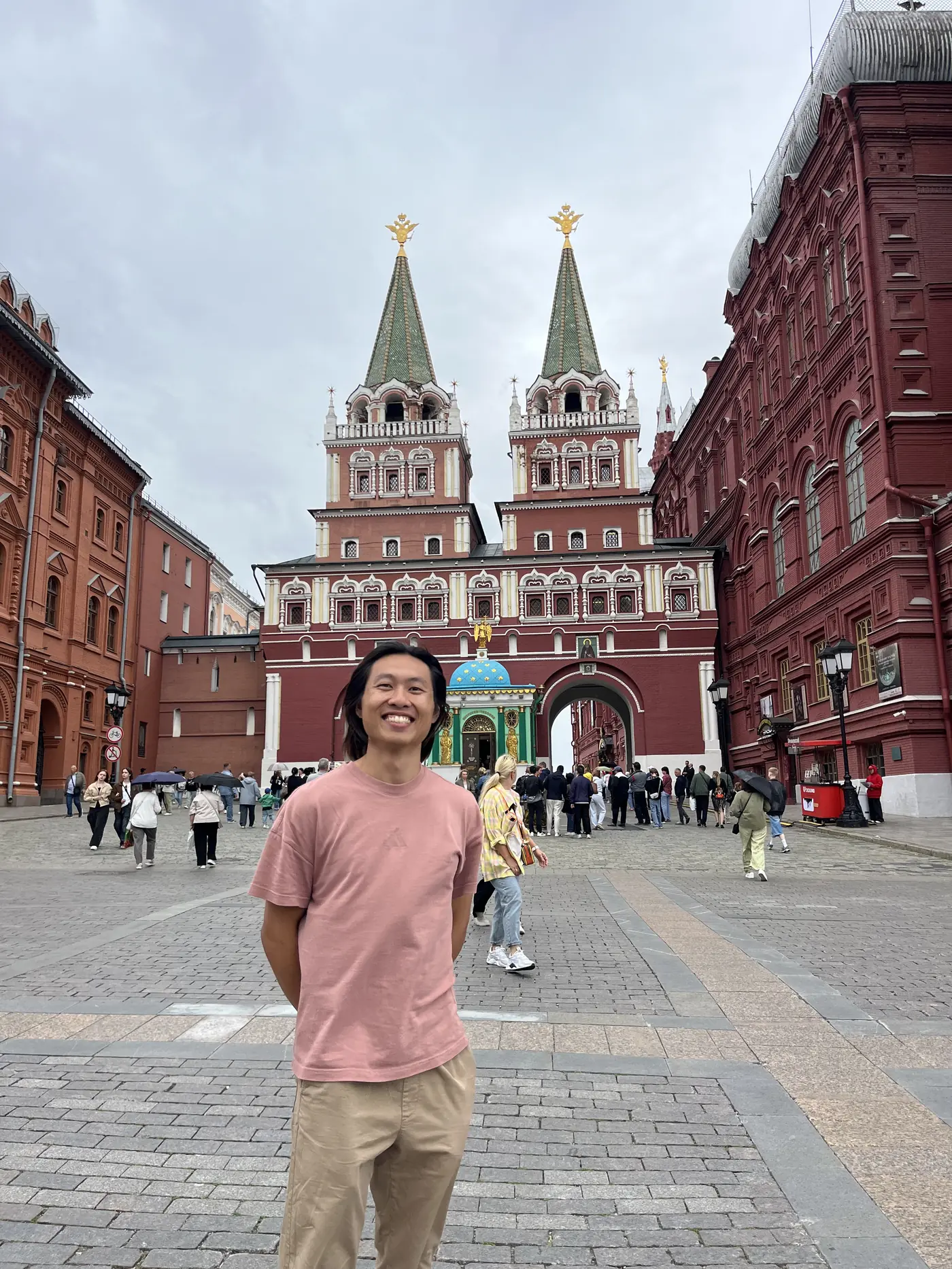 Shin in front of the Resurrection Gate (Voskresenskie vorota) entrance to Red Square, Moscow, with its twin red towers and green spires