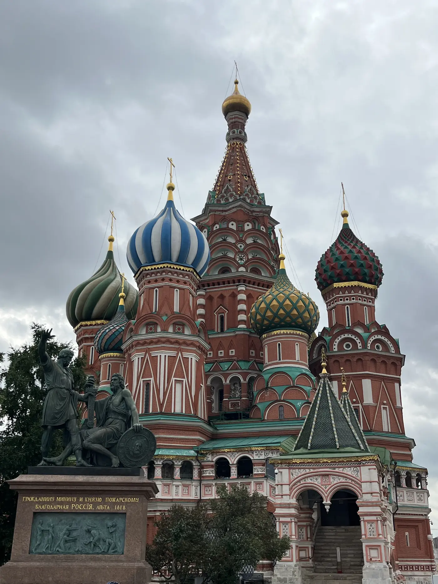 St. Basil's Cathedral close-up with colourful onion domes and Minin and Pozharsky monument on Red Square, Moscow, under dramatic clouds