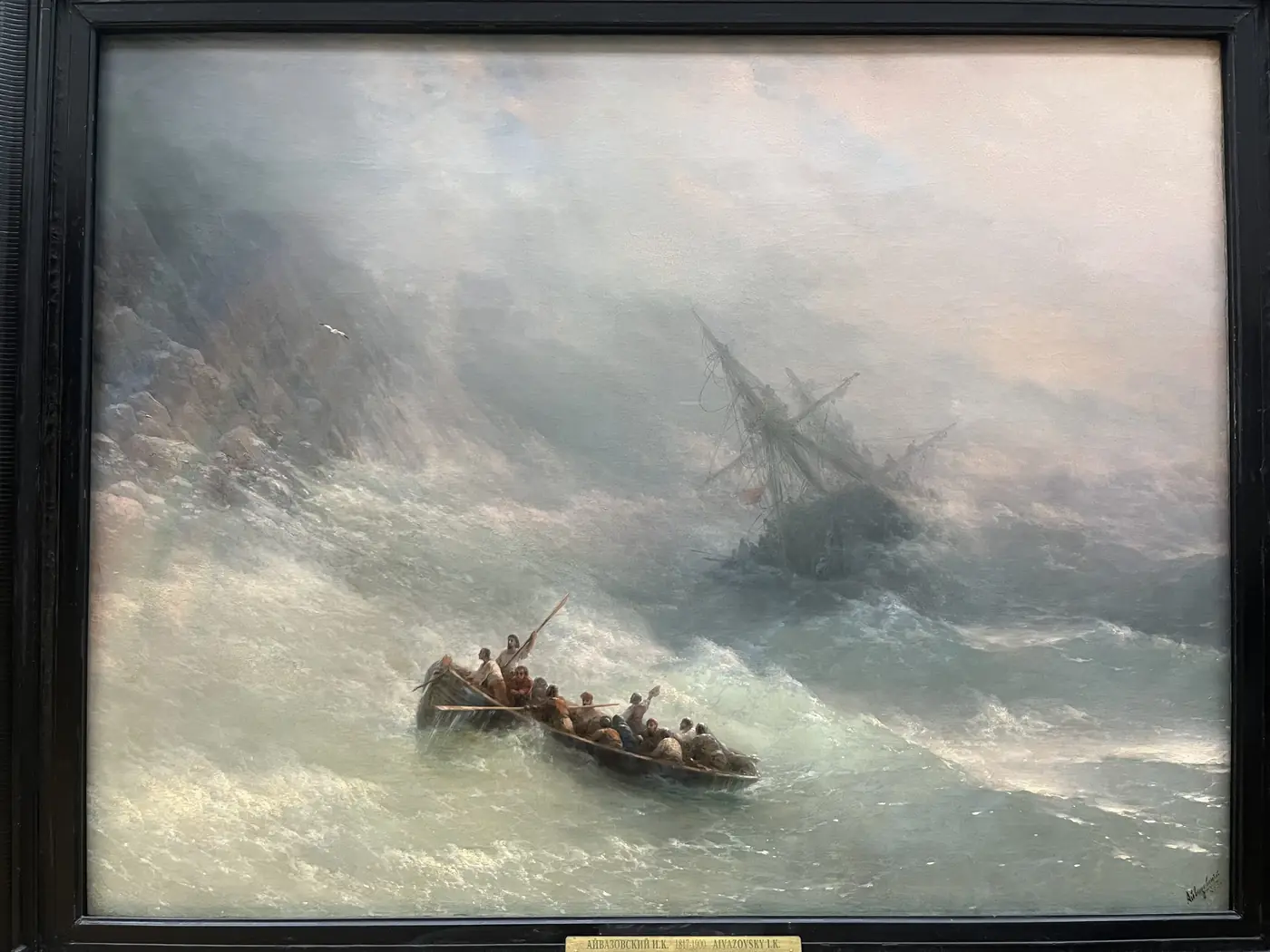 Aivazovsky painting of a shipwreck in stormy seas displayed in a Moscow art museum, oil on canvas with dramatic waves and survivors in a lifeboat