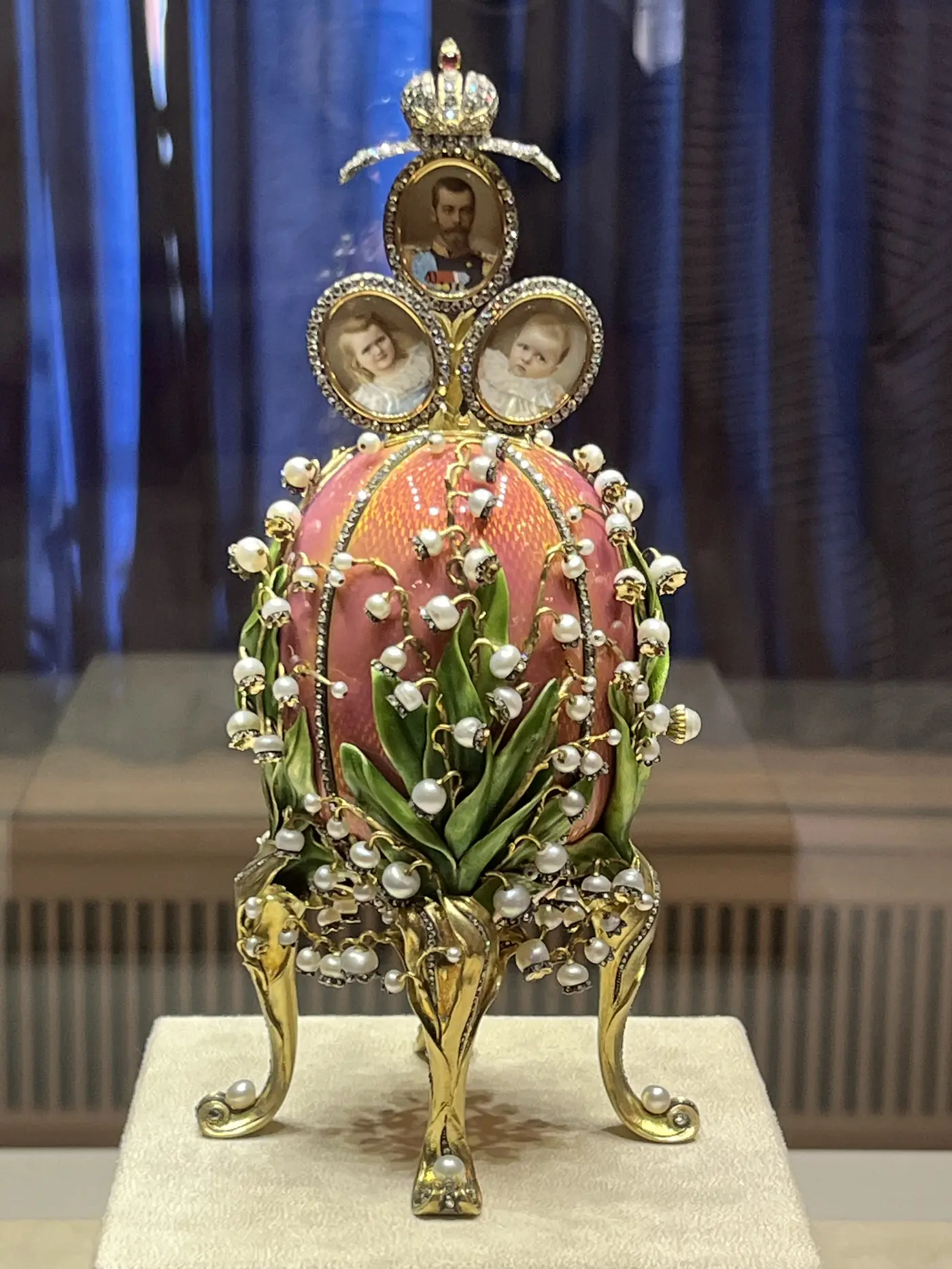 Close-up of a Fabergé Lily of the Valley egg in pink enamel with pearl flower clusters and a portrait miniature of Tsar Nicholas II on top