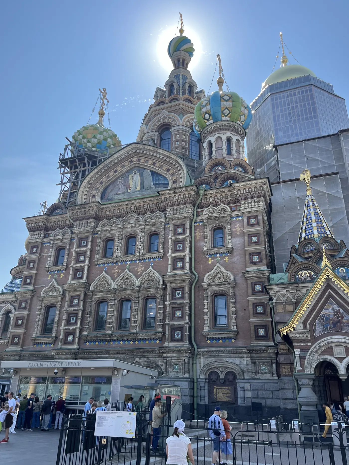 The Church of the Saviour on Spilled Blood in St. Petersburg, colourful onion domes against a clear blue sky, scaffolding on one side