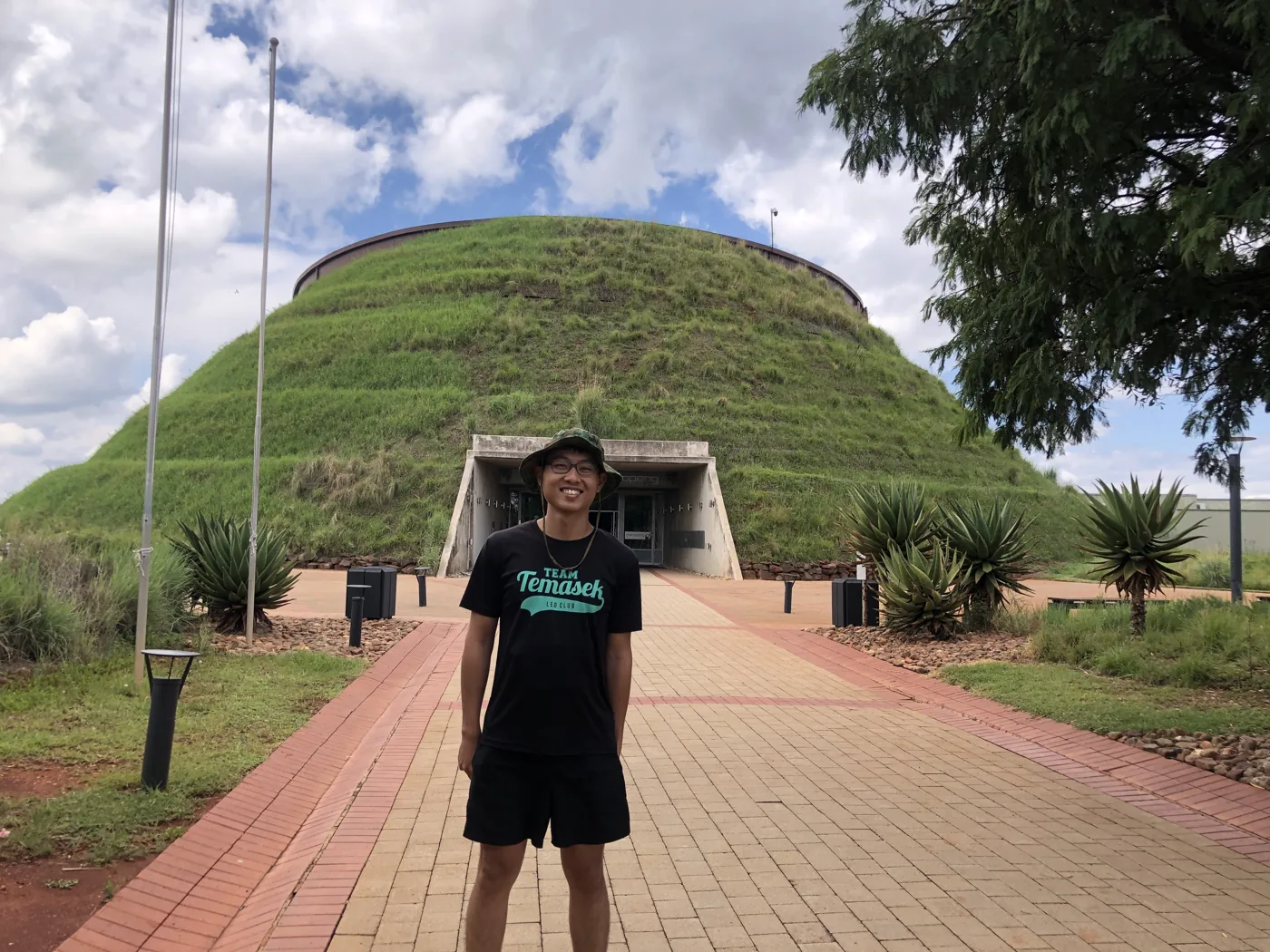 Standing in front of the grass-covered dome of the Maropeng Visitor Centre at the Cradle of Humankind