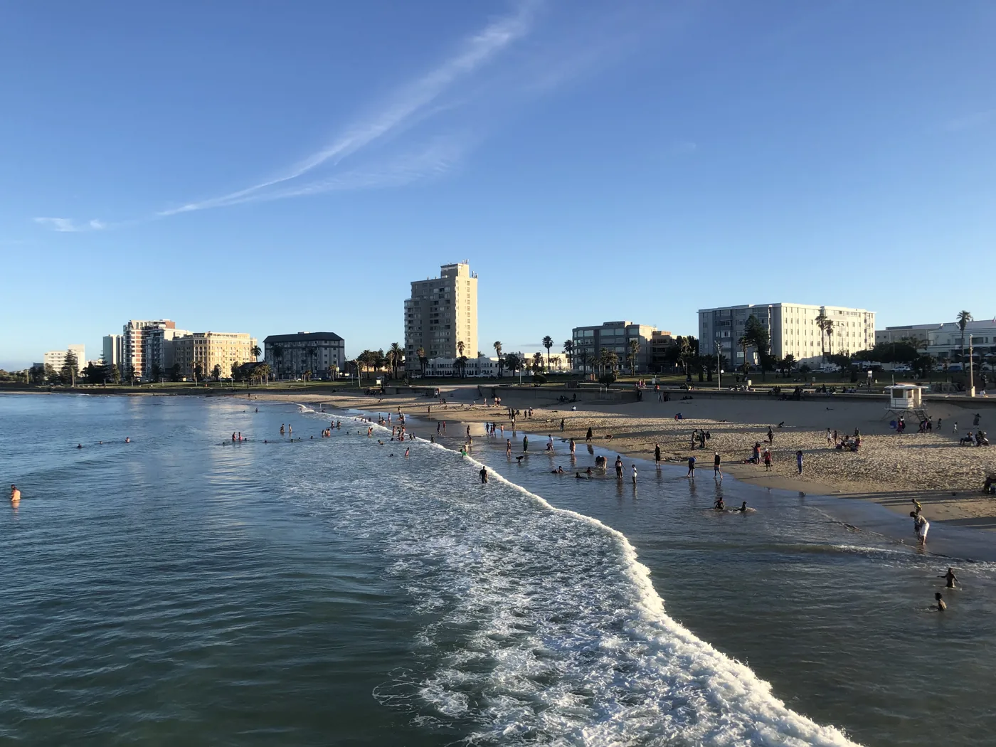 Port Elizabeth beachfront with gentle waves and city buildings in golden afternoon light