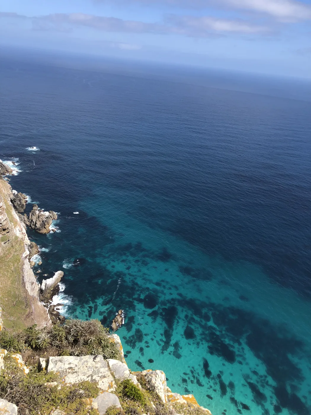 Turquoise ocean water and rocky coastline viewed from the Cape Point clifftops