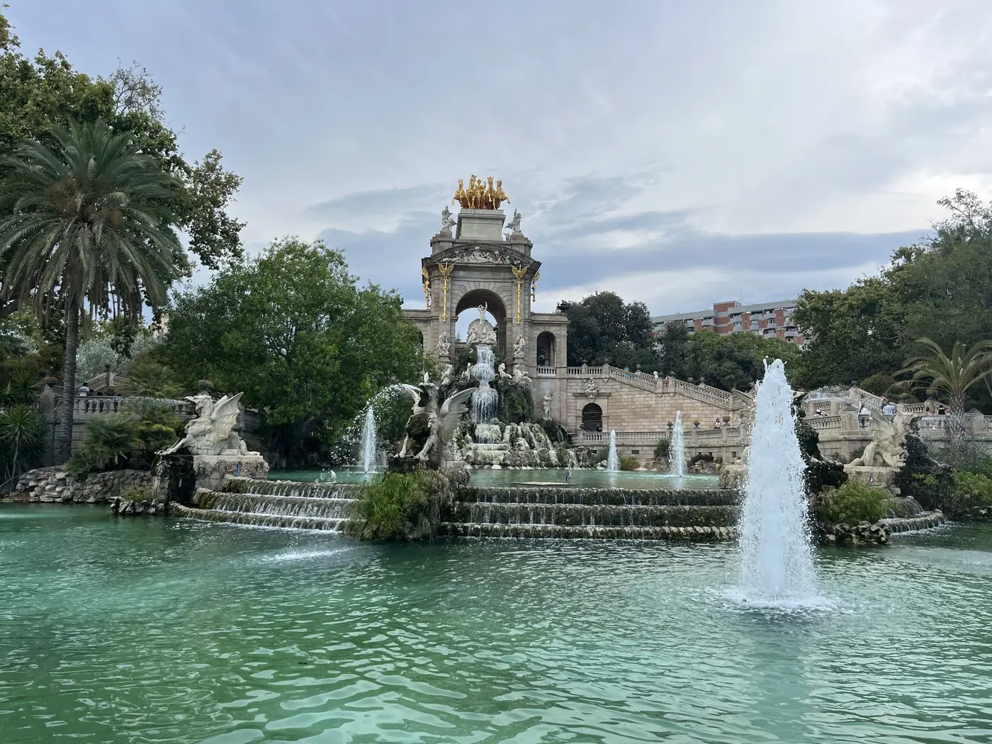 The Cascada Fountain in Parc de la Ciutadella, Barcelona, a golden ornate monument with fountains cascading into a green lake