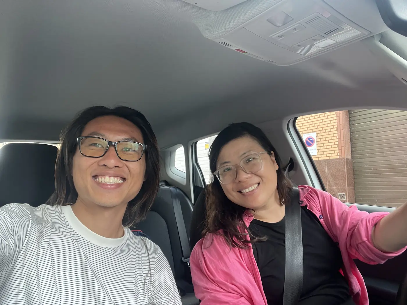 Shin and a friend smiling together inside a car in Las Palmas, Gran Canaria