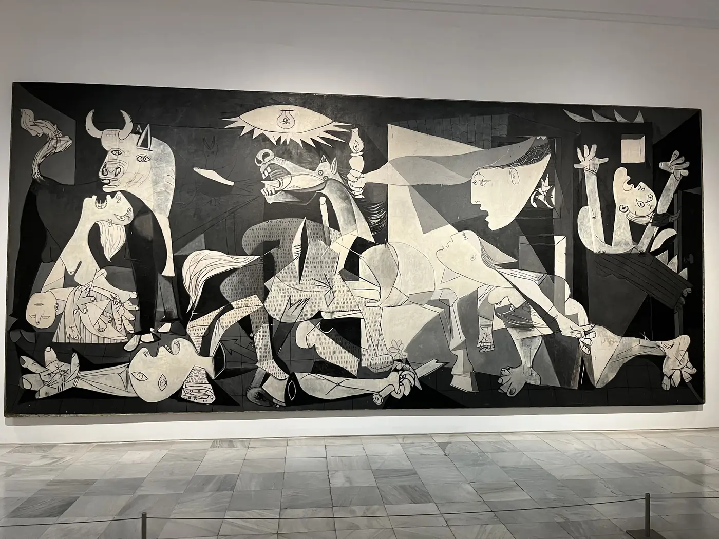 Picasso's Guernica displayed on a large gallery wall at the Museo Reina Sofía, Madrid, black-and-white cubist depiction of wartime suffering
