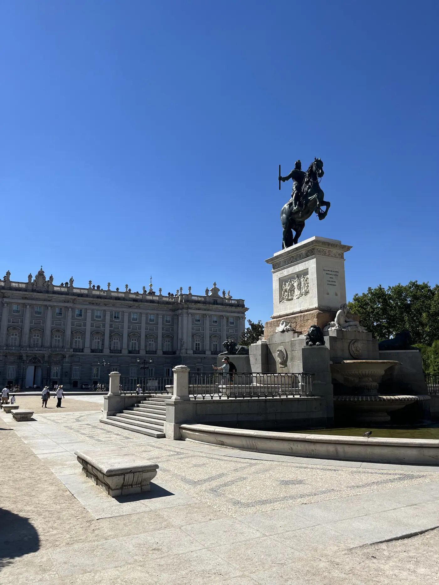 The Royal Palace of Madrid seen from Plaza de Oriente, with the bronze equestrian statue of Philip IV and a fountain in the foreground