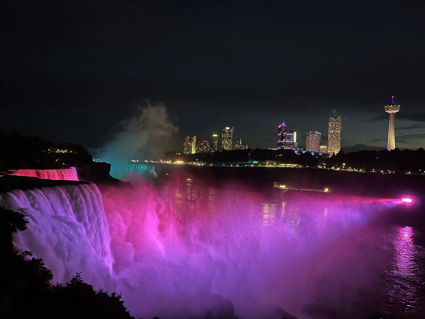 Niagara Falls illuminated in purple and pink at night