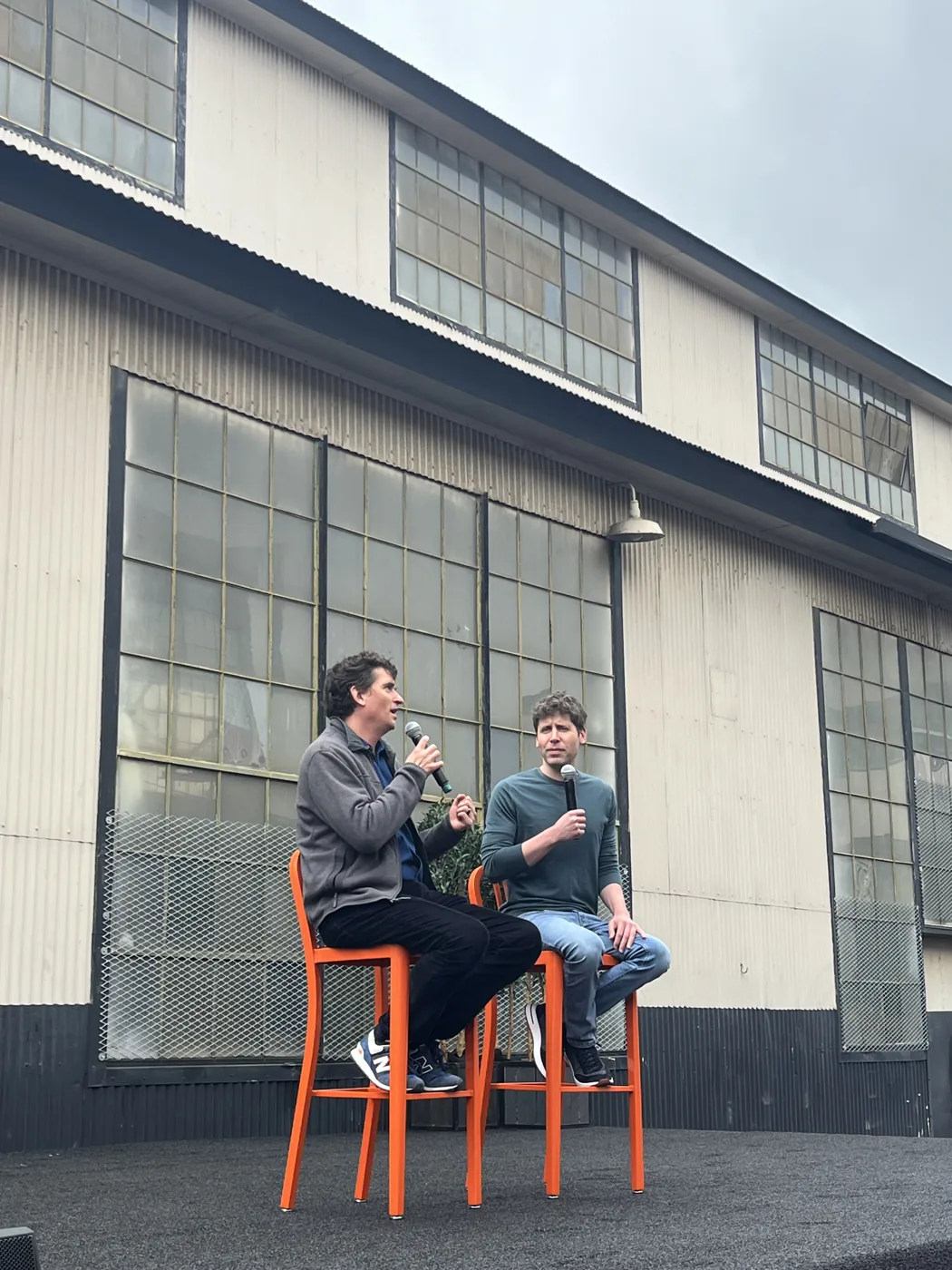 Two speakers on stage at outdoor tech event