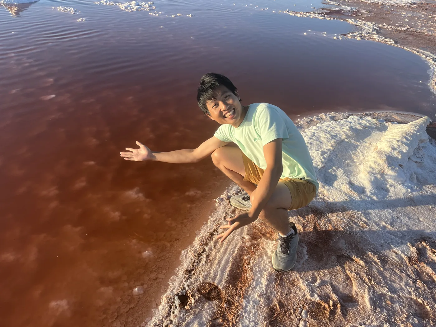 Crouching at pink salt flats of San Francisco Bay
