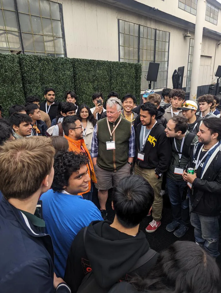 Large crowd gathered around a speaker at a startup event
