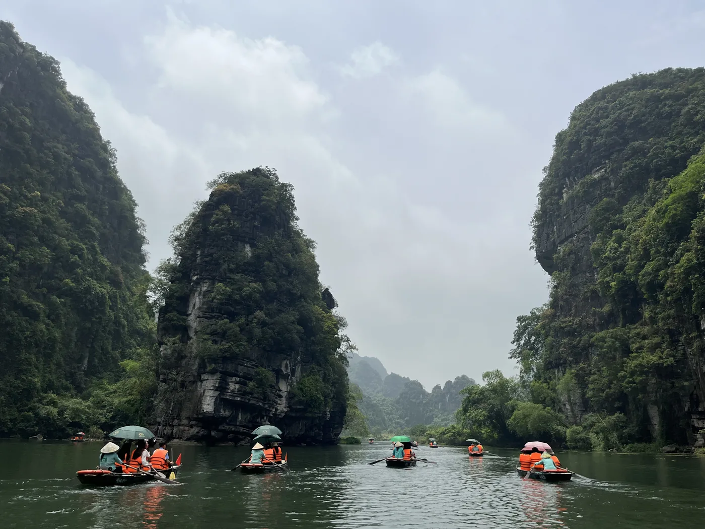 Row boats weaving through karst towers at Trang An, Ninh Binh